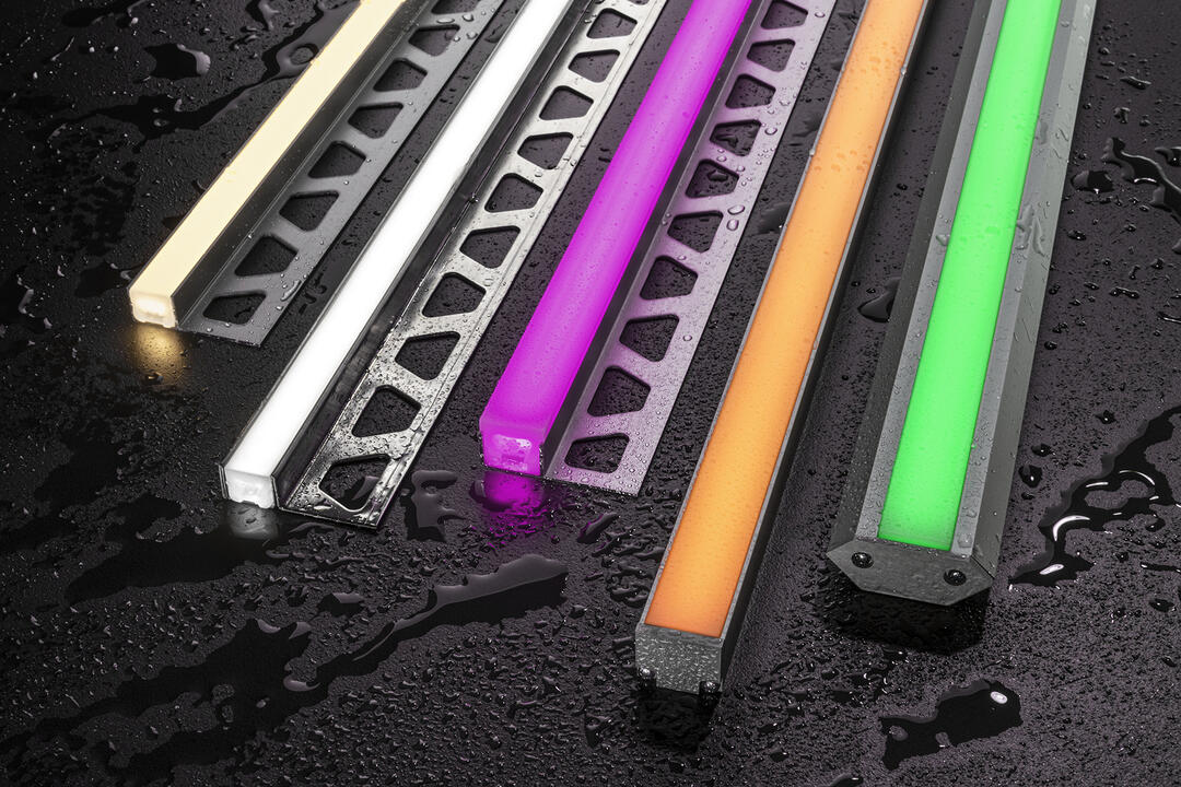Mehrere Schienen mit Lichtelementen, die neonfarben leuchten.