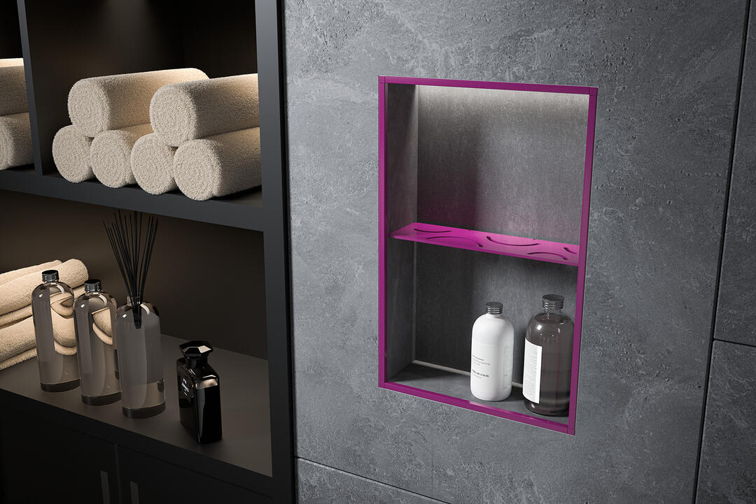 Eine in eine schwarze Wand eingelassene, pink beleuchtete Duschablage mit zwei Pflegeprodukten. Weiter links in einem Regal säuberlich aufgerollte Handtücher und weitere Pflegeprodukte. Alles ist minimalistisch und schick gehalten.